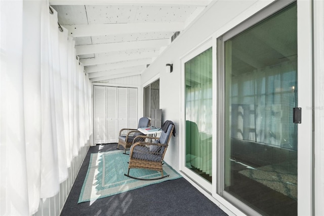 sunroom featuring lofted ceiling with beams