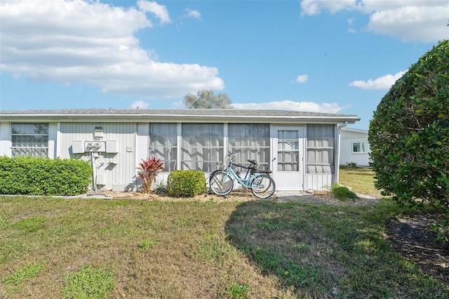 exterior space featuring a yard and a sunroom