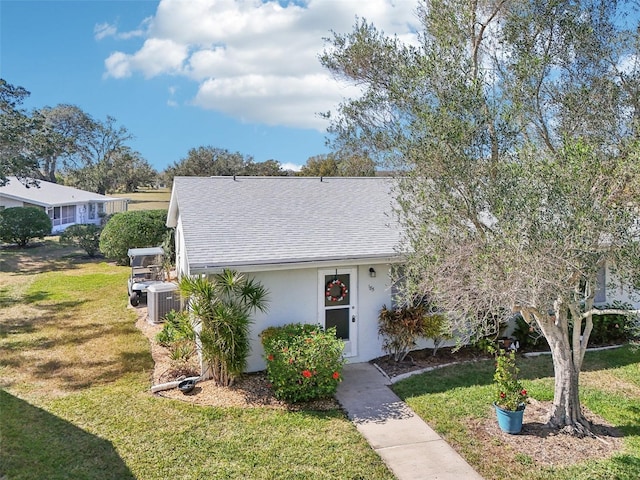 view of front facade featuring a front yard and cooling unit