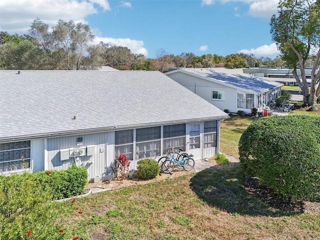 back of property featuring a sunroom and a yard