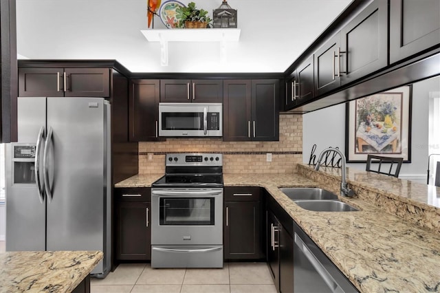 kitchen featuring light stone counters, sink, dark brown cabinets, and stainless steel appliances