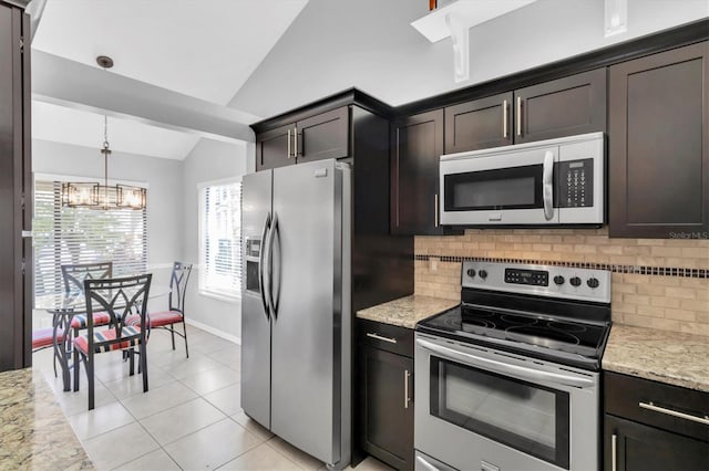 kitchen featuring dark brown cabinetry, stainless steel appliances, light stone countertops, and vaulted ceiling