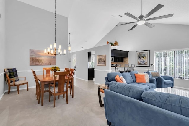 living room with light carpet, ceiling fan with notable chandelier, and high vaulted ceiling