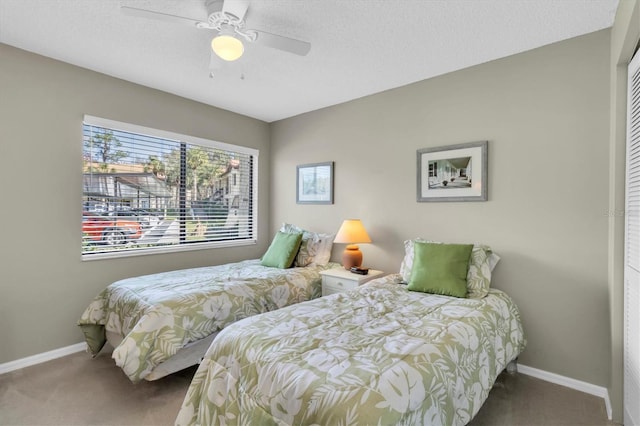 carpeted bedroom with ceiling fan, a textured ceiling, and a closet