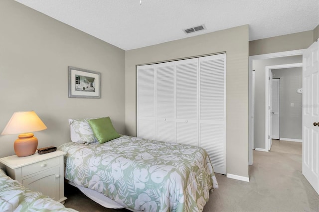 carpeted bedroom featuring a closet and a textured ceiling