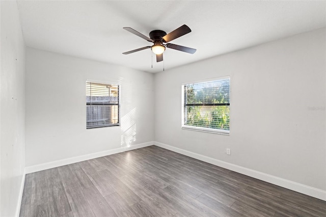 empty room featuring dark hardwood / wood-style flooring, ceiling fan, and a healthy amount of sunlight