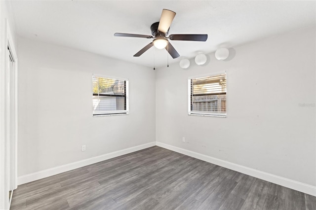 spare room with dark wood-type flooring, plenty of natural light, and ceiling fan