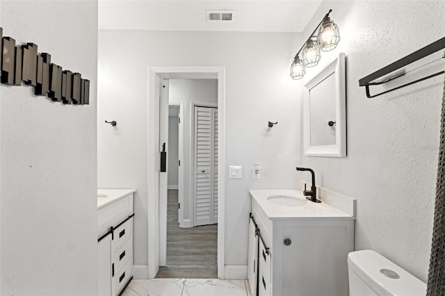 bathroom featuring vanity and toilet