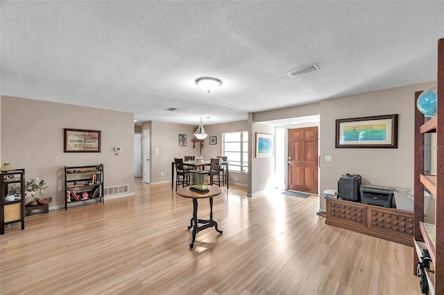 interior space featuring a textured ceiling and light hardwood / wood-style floors