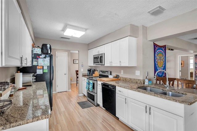 kitchen featuring sink, white cabinetry, light stone counters, black appliances, and light wood-type flooring