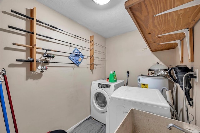 laundry room with electric water heater, independent washer and dryer, and a textured ceiling