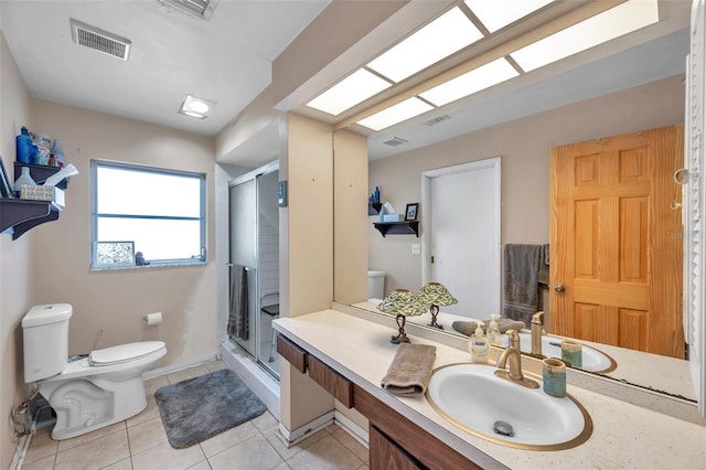 bathroom featuring vanity, toilet, tile patterned flooring, and a shower with door