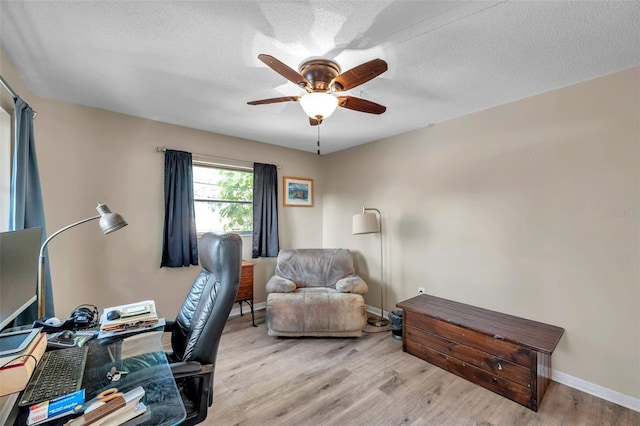 office with ceiling fan, light hardwood / wood-style flooring, and a textured ceiling