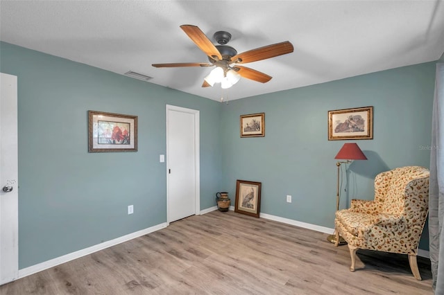 living area featuring light hardwood / wood-style flooring and ceiling fan