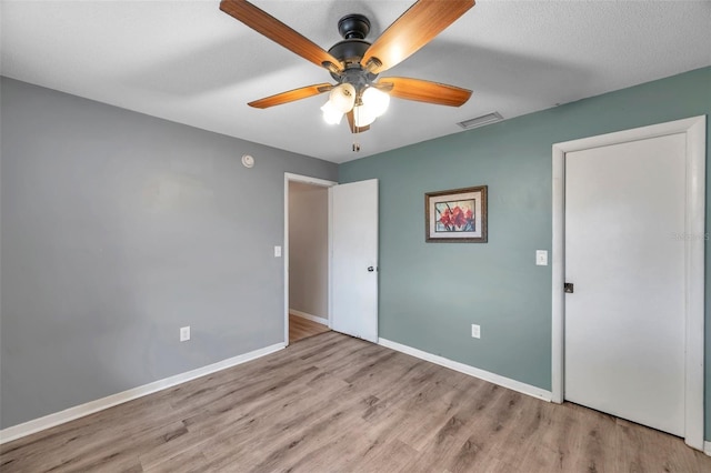 unfurnished bedroom with ceiling fan, a textured ceiling, and light wood-type flooring