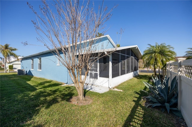 back of property featuring a sunroom, cooling unit, and a lawn