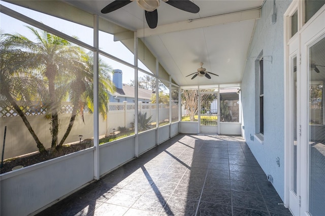 unfurnished sunroom featuring vaulted ceiling with beams and ceiling fan