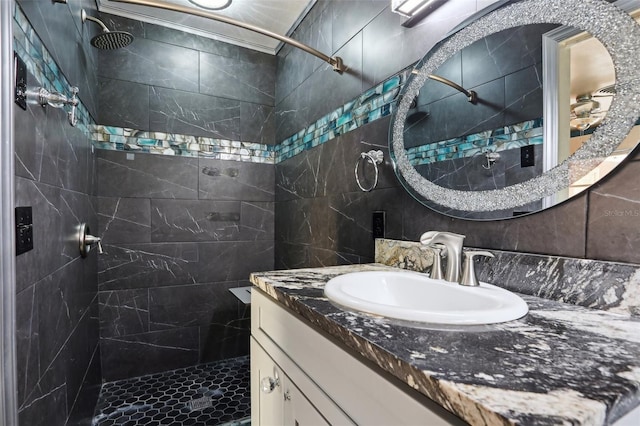 bathroom featuring vanity, a tile shower, backsplash, and tile walls