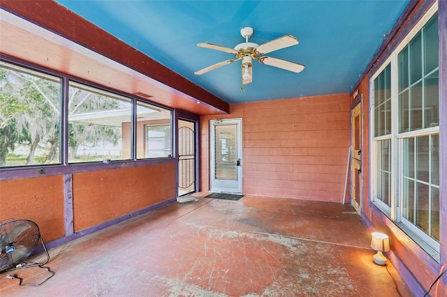 unfurnished sunroom featuring ceiling fan