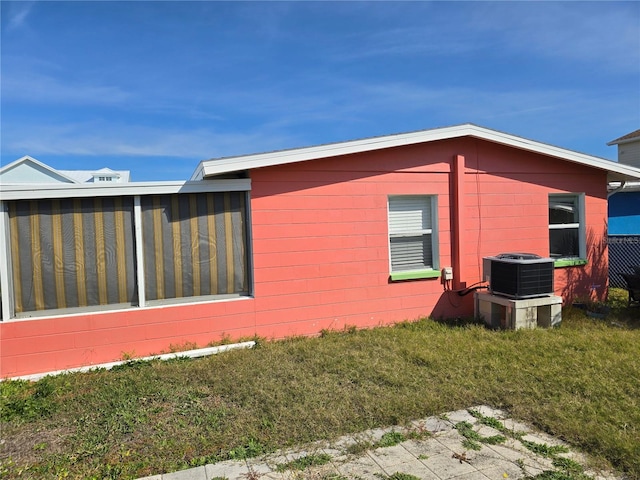 view of side of home with a lawn and central air condition unit