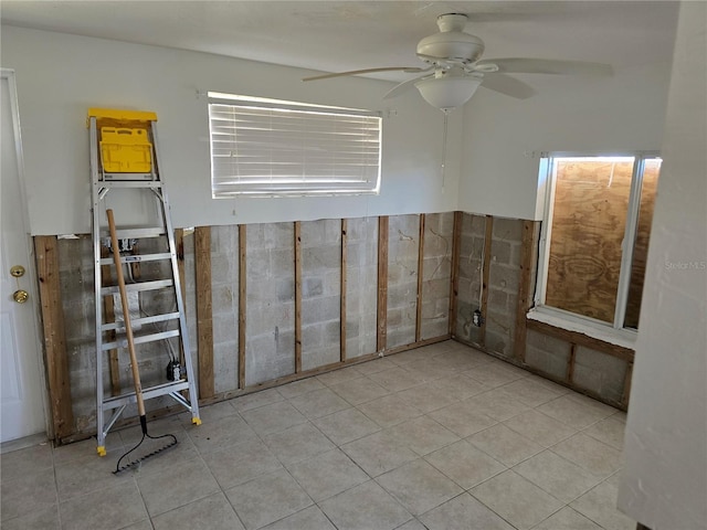 tiled empty room featuring ceiling fan