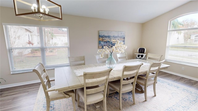 dining space featuring hardwood / wood-style flooring and an inviting chandelier