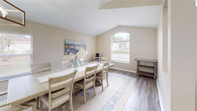 dining space with vaulted ceiling, dark wood-type flooring, and a chandelier