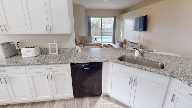 kitchen featuring black dishwasher, sink, and white cabinets