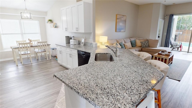 kitchen with dishwasher, sink, pendant lighting, and a breakfast bar