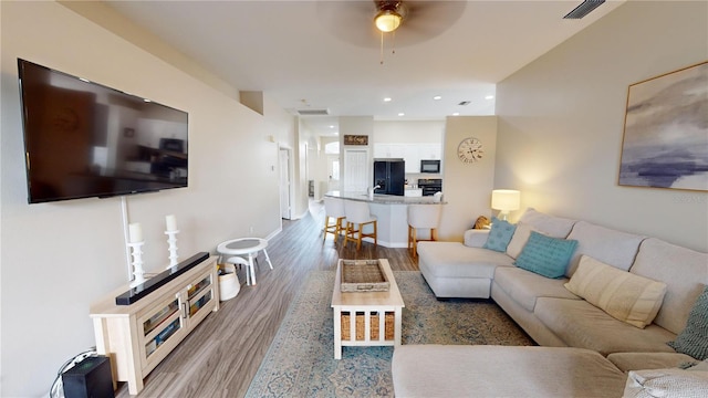 living room with ceiling fan and hardwood / wood-style floors