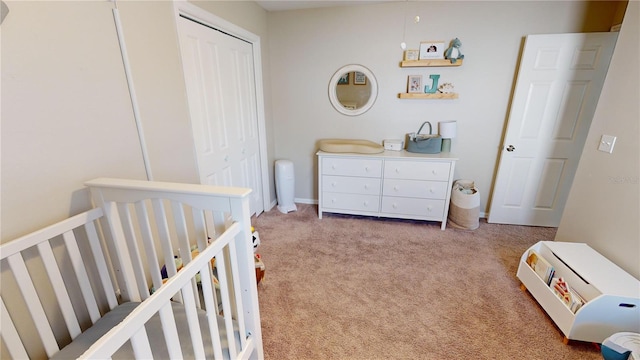 bedroom featuring a crib, carpet floors, and a closet