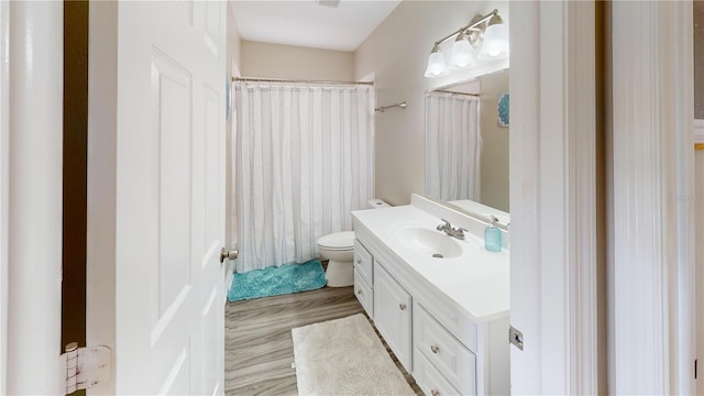 bathroom featuring hardwood / wood-style flooring, vanity, curtained shower, and toilet