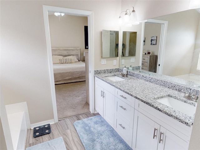 bathroom featuring hardwood / wood-style flooring, vanity, and a tub