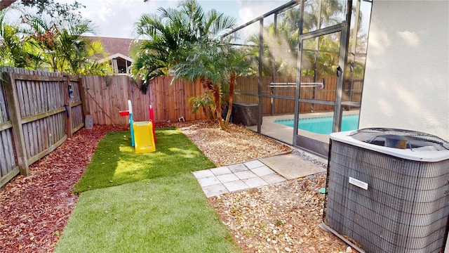 view of yard featuring central AC unit and a fenced in pool