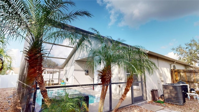 exterior space featuring central AC unit, a lanai, and a fenced in pool