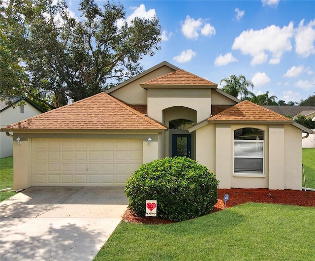 mediterranean / spanish-style house featuring a garage and a front lawn