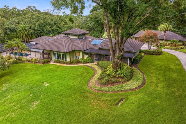 view of front of home featuring a front lawn and solar panels