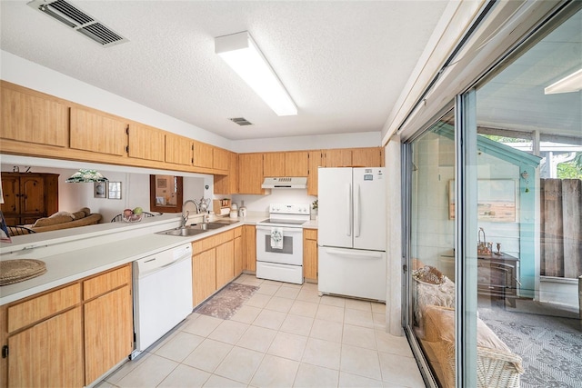 kitchen with sink, white appliances, light tile patterned floors, and a textured ceiling