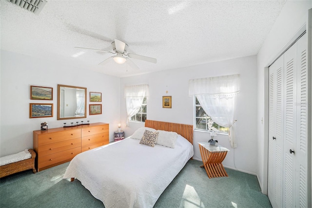 carpeted bedroom with ceiling fan, a closet, and a textured ceiling