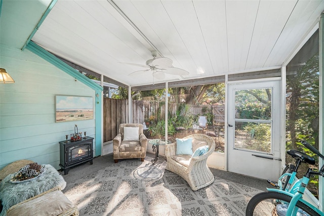 sunroom with wood ceiling, ceiling fan, and a wood stove