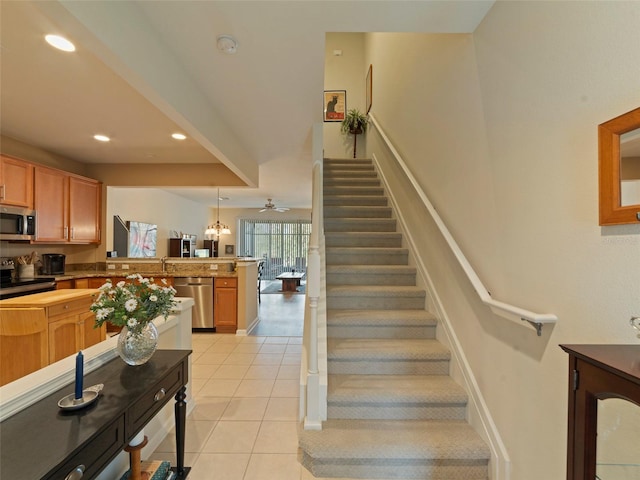 stairs with tile patterned floors and ceiling fan