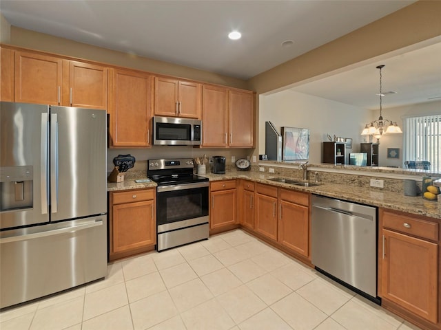 kitchen featuring appliances with stainless steel finishes, sink, hanging light fixtures, light tile patterned floors, and light stone counters