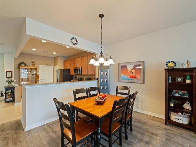 dining area featuring an inviting chandelier and light wood-type flooring