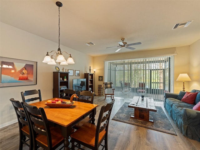 dining space with dark hardwood / wood-style floors and ceiling fan with notable chandelier