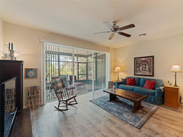 living room with ceiling fan and light hardwood / wood-style flooring