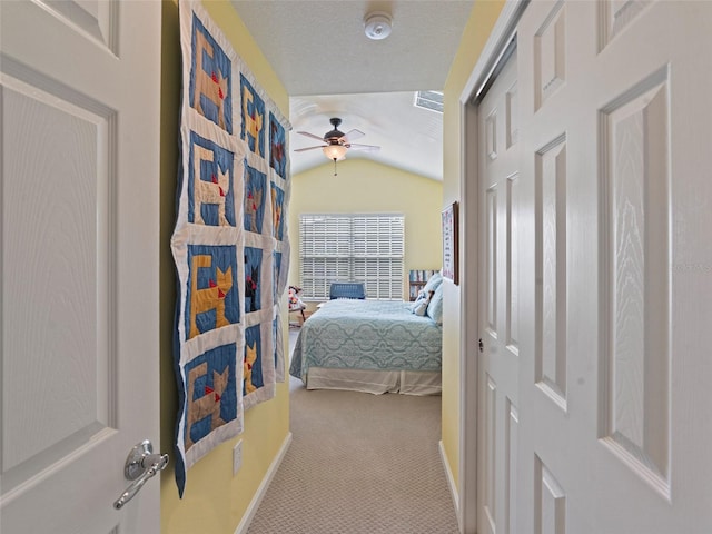 bedroom featuring vaulted ceiling, light carpet, and a textured ceiling