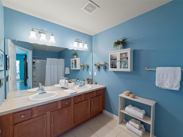 bathroom with tile patterned flooring, vanity, and curtained shower