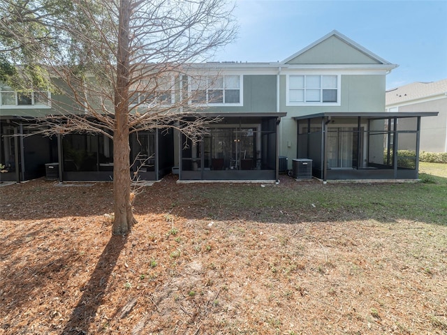 back of property with a sunroom, a yard, and cooling unit