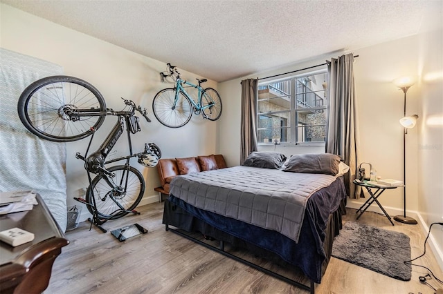 bedroom with hardwood / wood-style floors and a textured ceiling