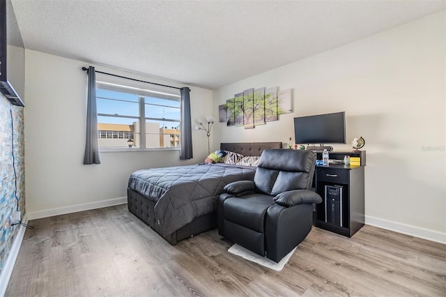 bedroom with wood-type flooring and a textured ceiling